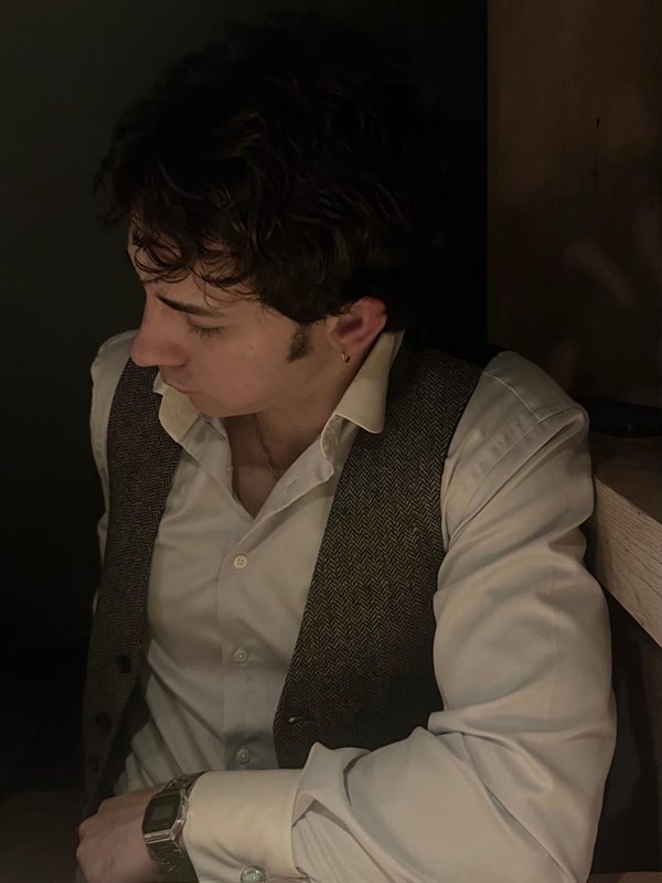 Black and white portrait of the owner of BAELISH in a herringbone waistcoat, looking down