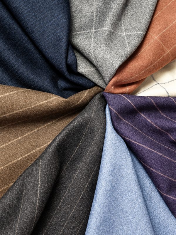 Fine suiting cloths in navy, grey, rust and plum, fanned out together